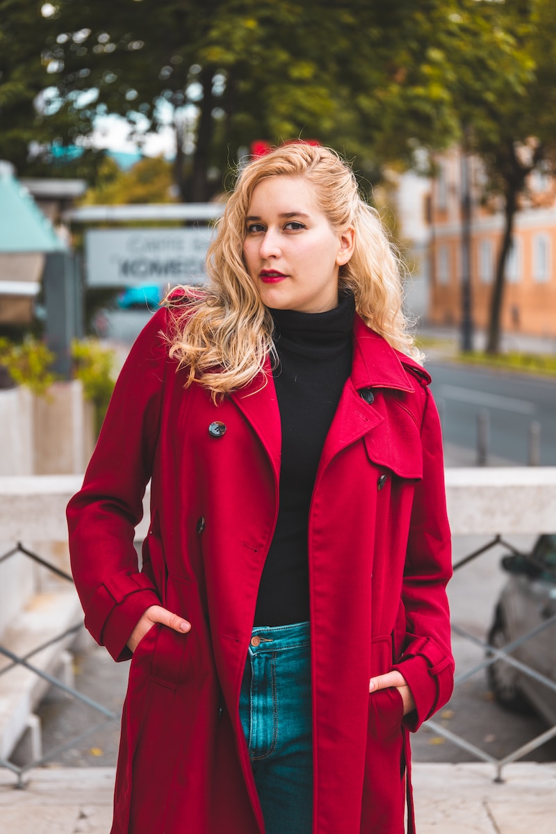 a woman in a red coat is posing for a picture